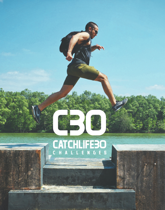 Man jumping across a ledge over the catchlife30 logo, with a forrest and water in the background